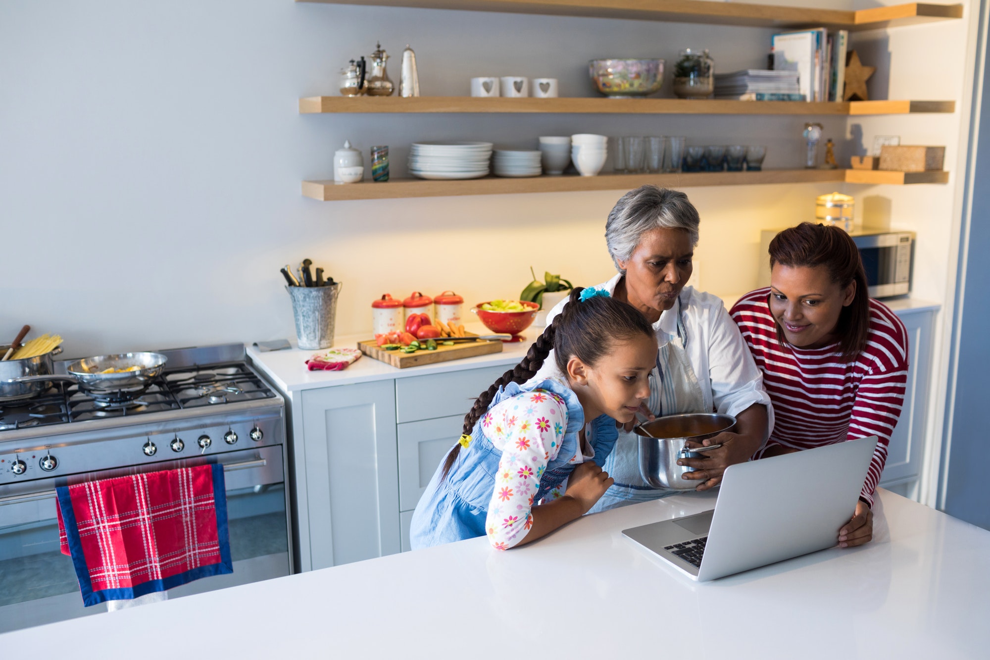 Happy family using laptop in kitchen worktop